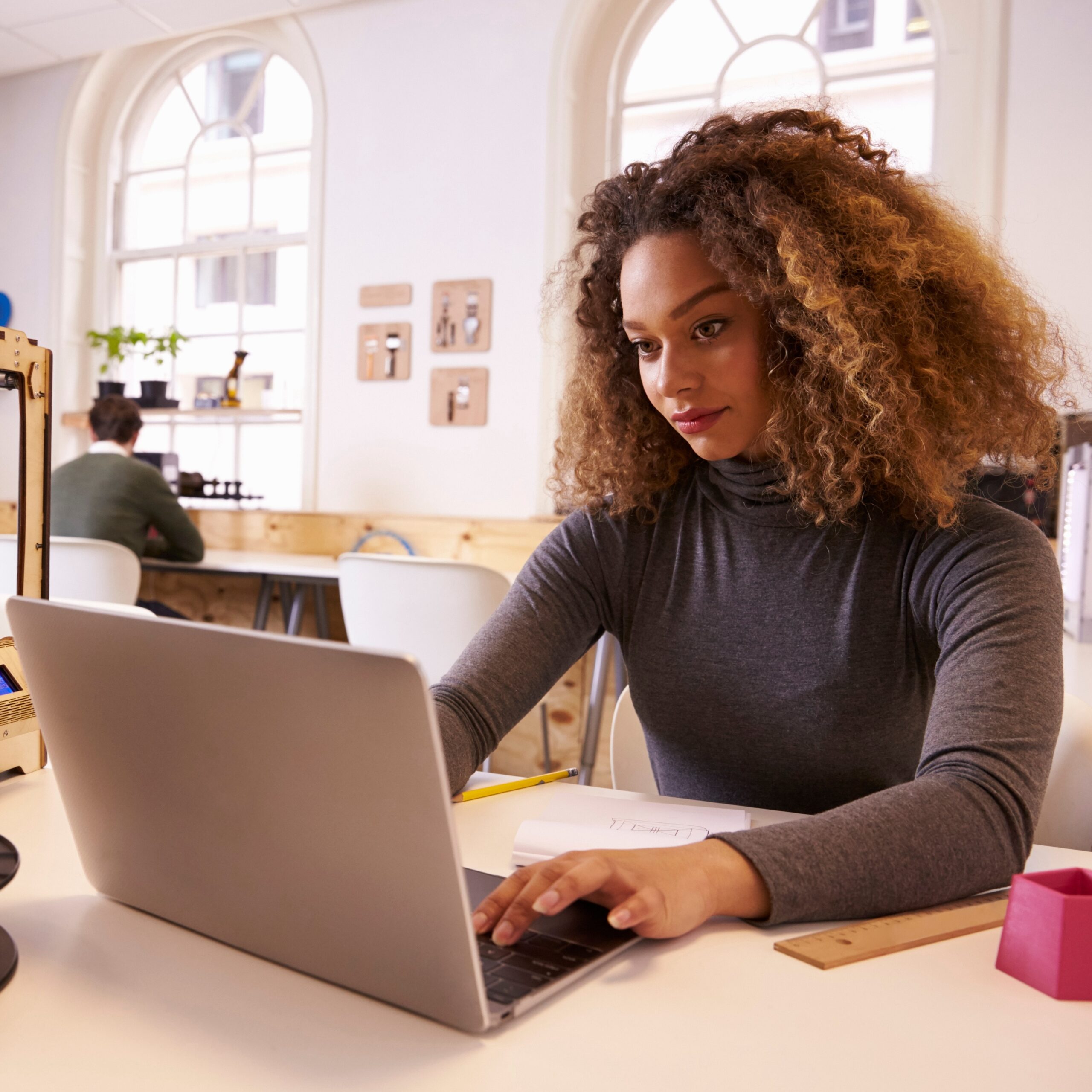 Woman working at a desk typing on a laptop