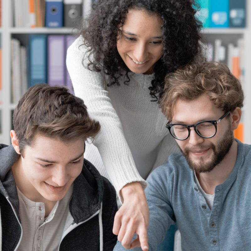 Three young professionals in a library