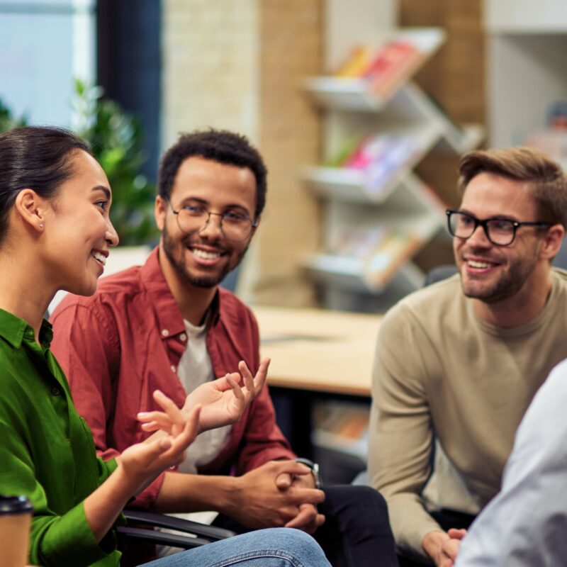 Group of young happy multi racial business people communicating and sharing ideas while working together in the modern office.