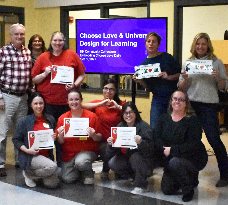 A group of adults from the Choose Love project smiling at the camera, Two groups of adult learners posing by making heart shapes with their hands