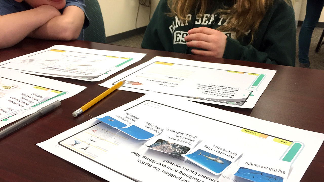 Students looking at a paper prototype