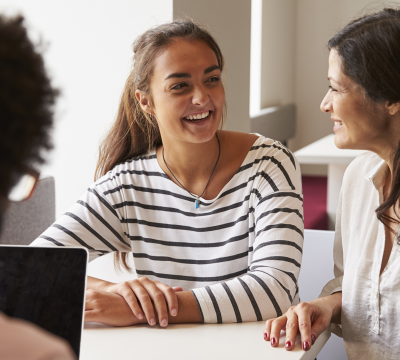 Photo of a mother and daughter speaking with an educator