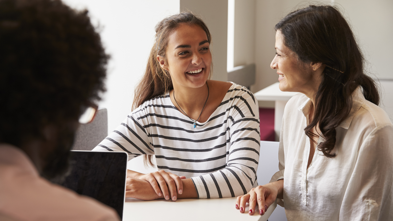 Photo of a mother and daughter speaking with an educator