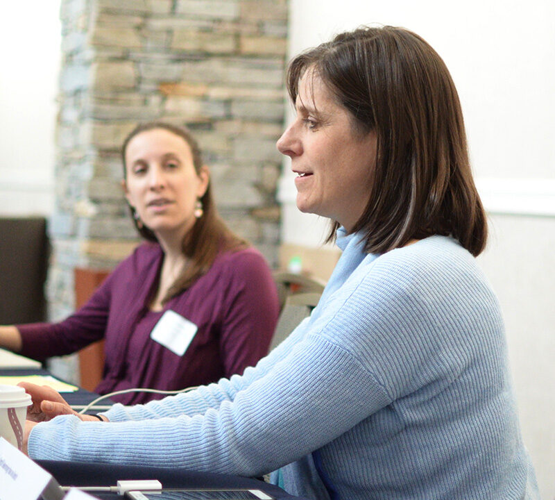 Photo of Jennifer Levine working at a computer with a colleague