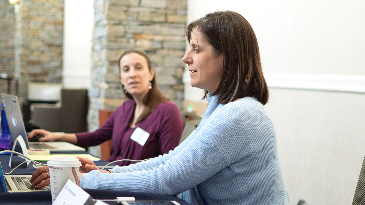 Photo of Jennifer Levine working at a computer with a colleague