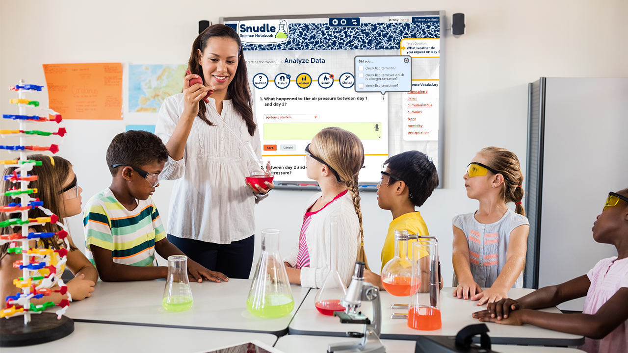 A science teacher working with students, SNUDLE projected on a whiteboard behind them