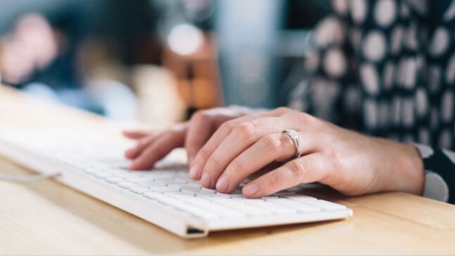 Photo of a woman typing on a keyboard