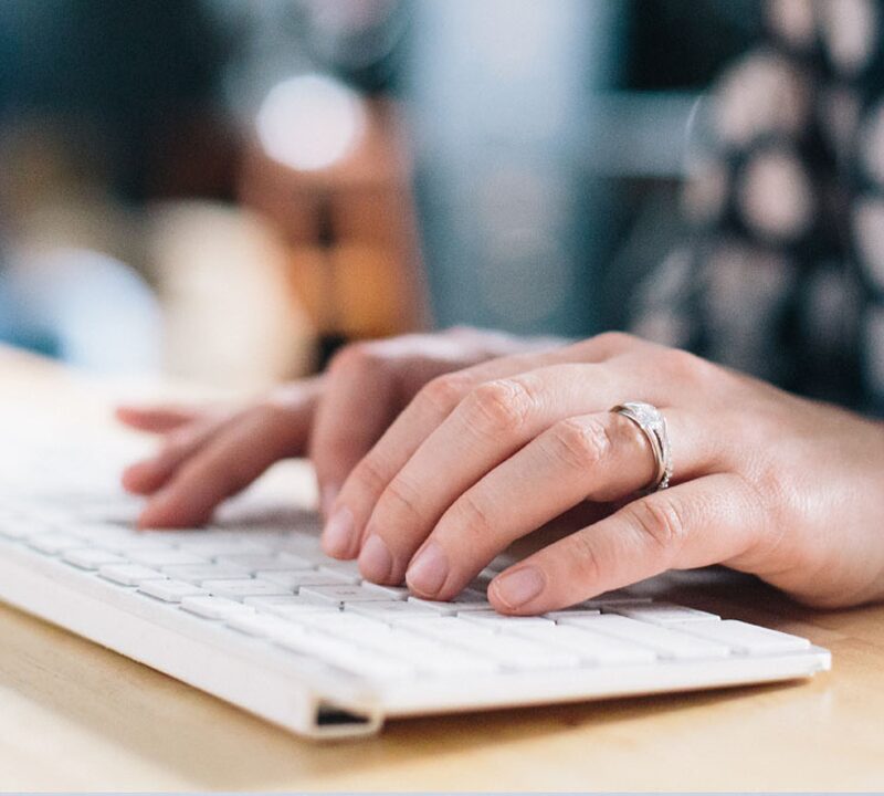 Photo of a woman typing on a keyboard