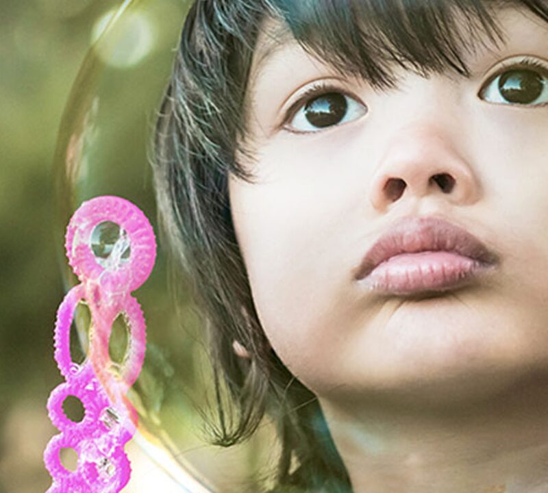 Photo of a boy seen through a large bubble