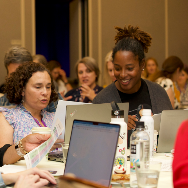 Photo of two conference attendees engaged in discussion during a session.